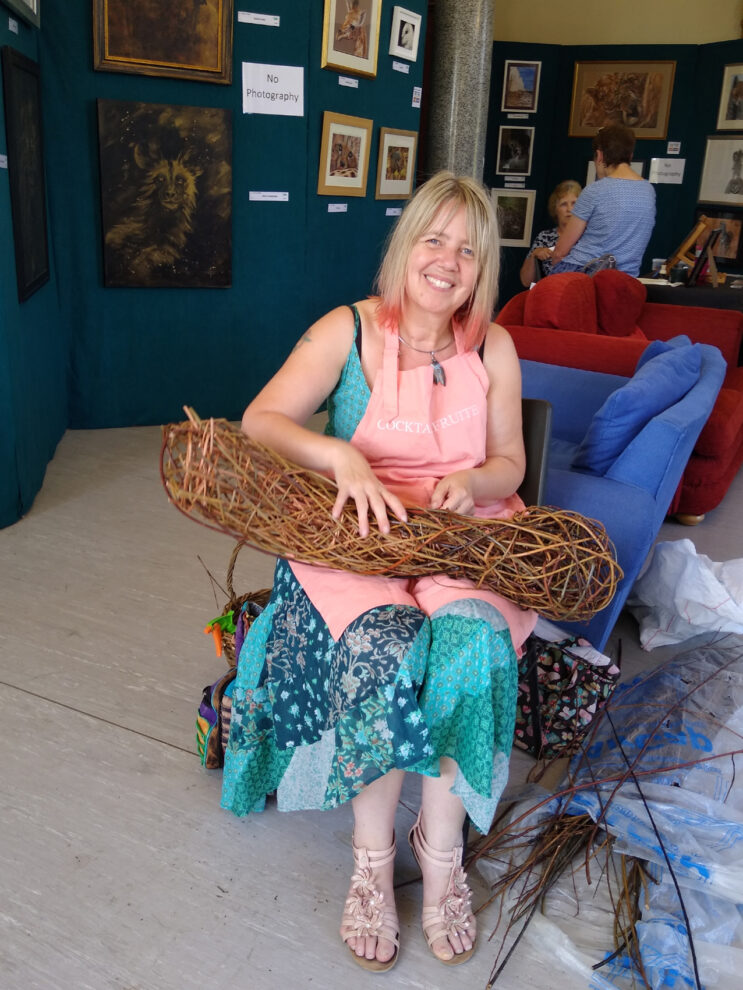 Photo of Jacqueline Rolls creating a new willow sculpture at the Southern Nature Arts show 