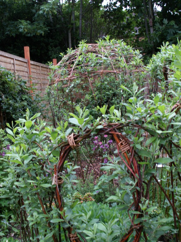 photo of willow fedge and arbour looking through round window